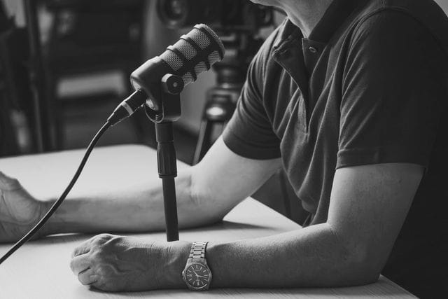 Invité parlant au micro lors de l’enregistrement d’un podcast